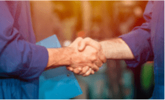 Close up of two people in blue maintenance jumpsuits shaking hands in agreement of partnering with Riverside Integrated Solutions